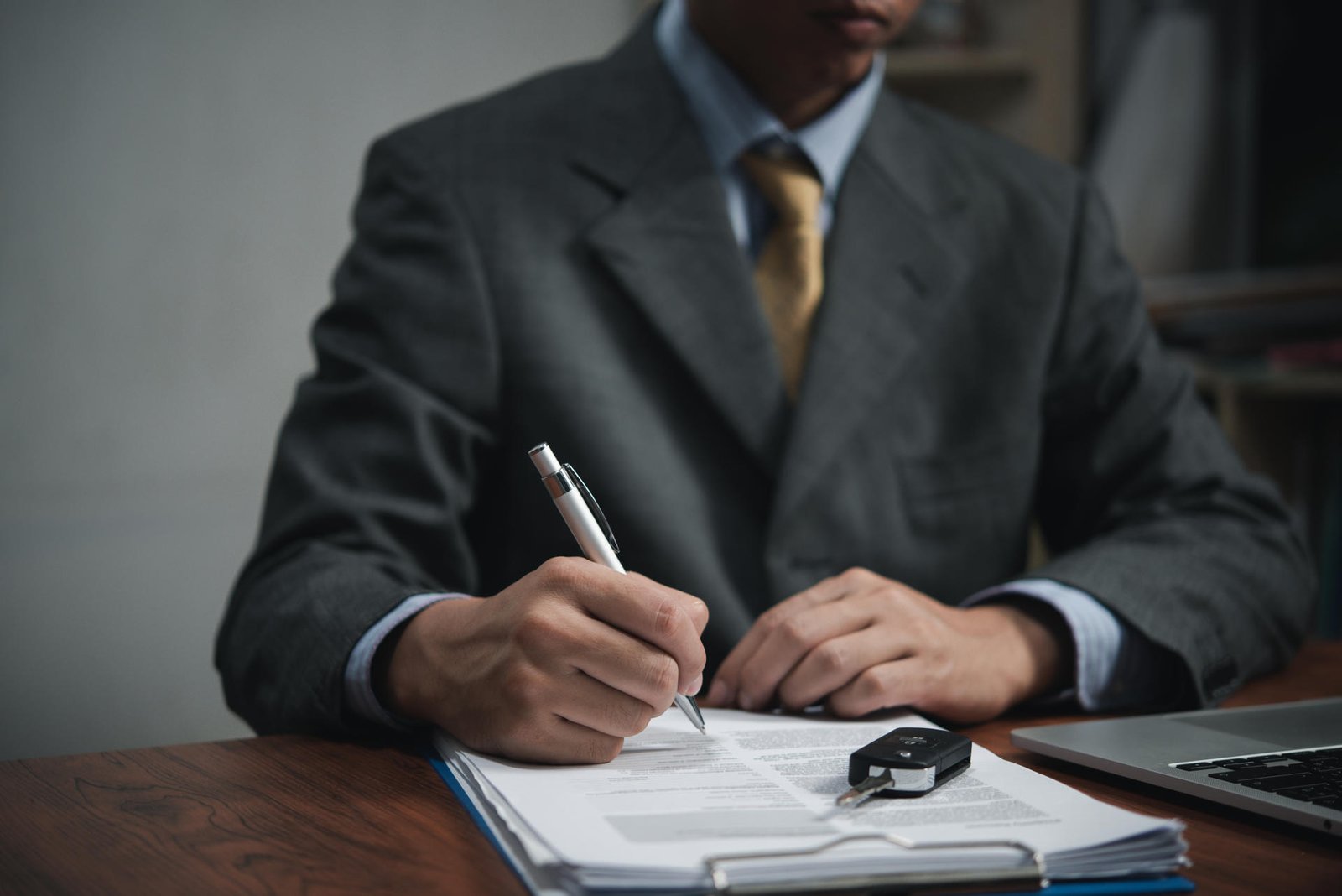 Businessman signing a contract for buying of selling a car.Car rental service. insurance, and contract agreement concepts